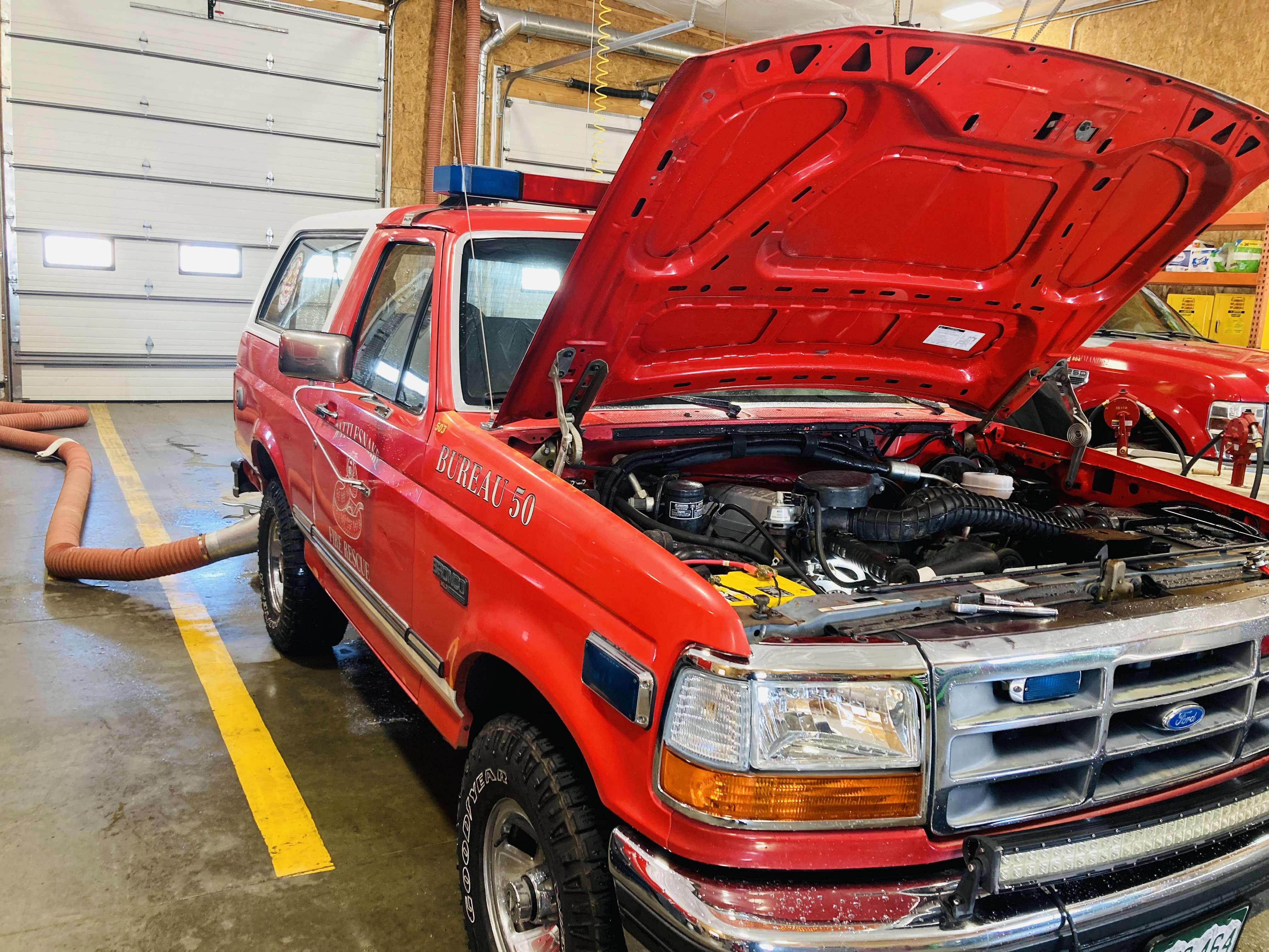 Our investigations truck Bureau 251 with the hood up in the fleet shop